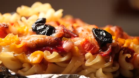 close-up of baked pasta casserole with chicken, peppers, and olives
