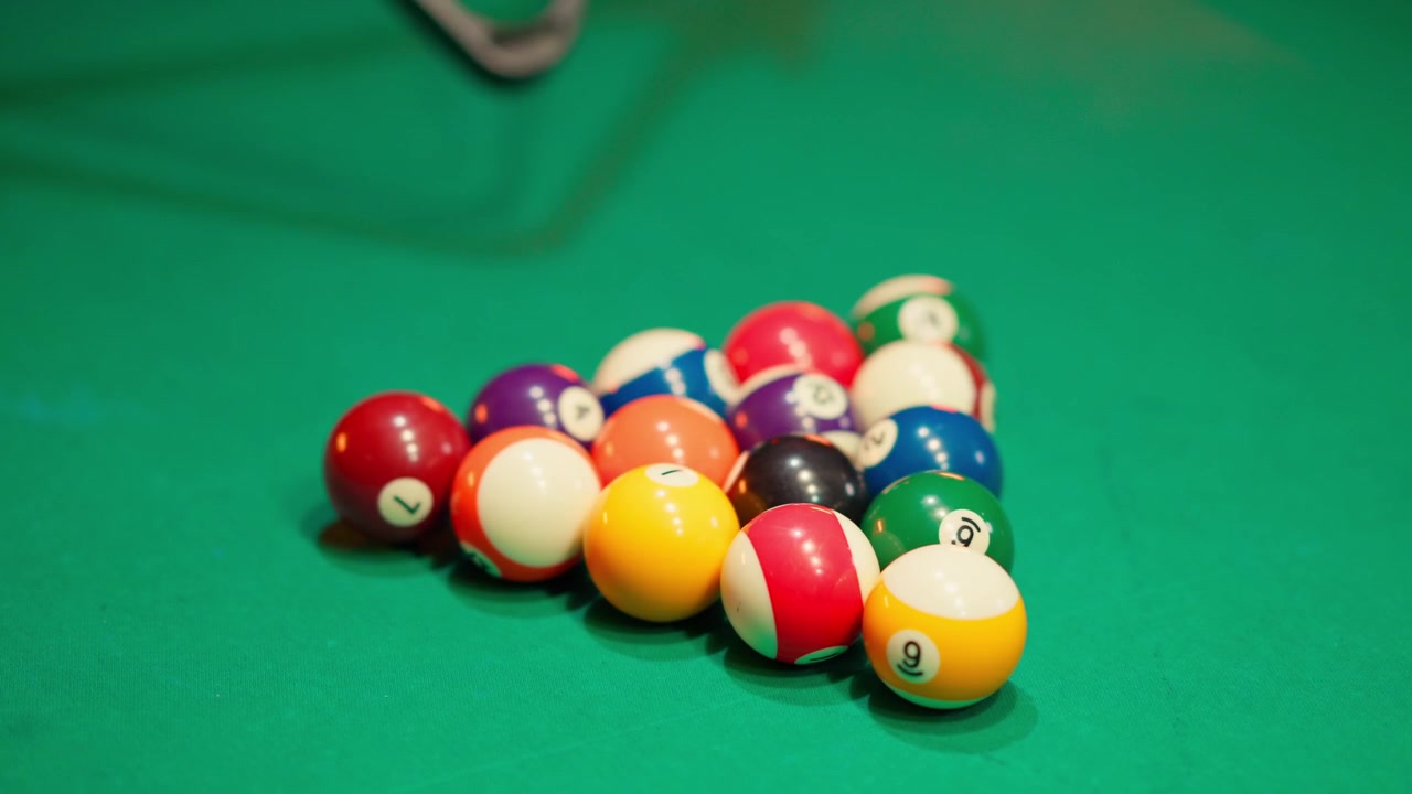 Hands Racking Billiard Balls on a Green Pool Table