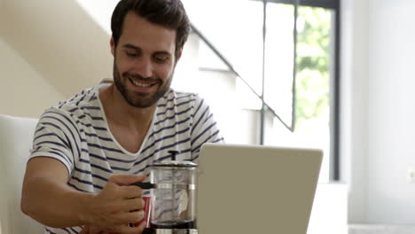 el hombre está sirviendo café en una taza.