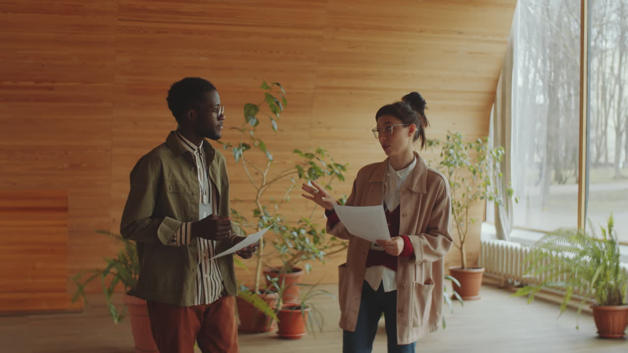 trabajadores de bibliotecas multiétnicos discutiendo documentos en el auditorio