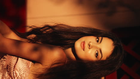 close up portrait shot of pretty young brunette woman dressed in exquisite pink ball gown posing in front of a camera