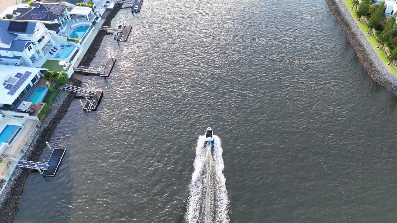 A boat travels along a residential river