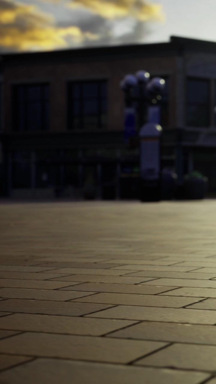 Persone camminano su una piazza in una città al tramonto con edifici nelle vicinanze