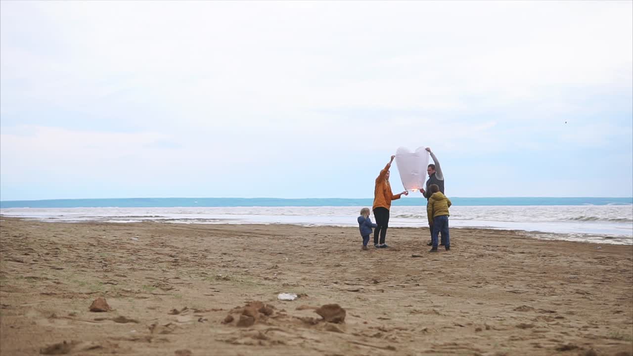 Family Launching a Sky Lantern on the Beach