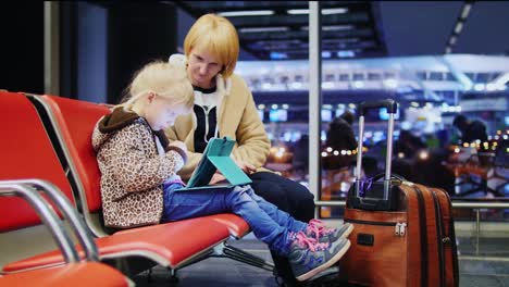 Madre-E-Hija-Esperando-Su-Vuelo-Niña-Jugando-En-Una-Tableta