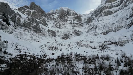 Klöntalersee-Suiza-épico-Vuelo-Lateral-De-Picos-Montañosos-Con-Nubes-Rodando-Por-La-Nieve