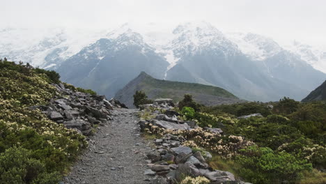 A-beautiful-hiking-path-with-a-view-of-a-misty-and-snowy-mountain-in-the-background