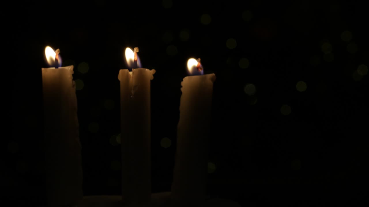 tres velas encendidas en la noche, una fuente de luz en la oscuridad