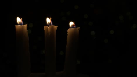 tres velas encendidas en la noche, una fuente de luz en la oscuridad