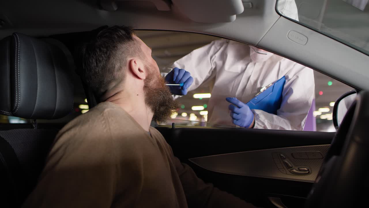 video del conductor durante el procedimiento de prueba de coronavirus drive-thru pcr