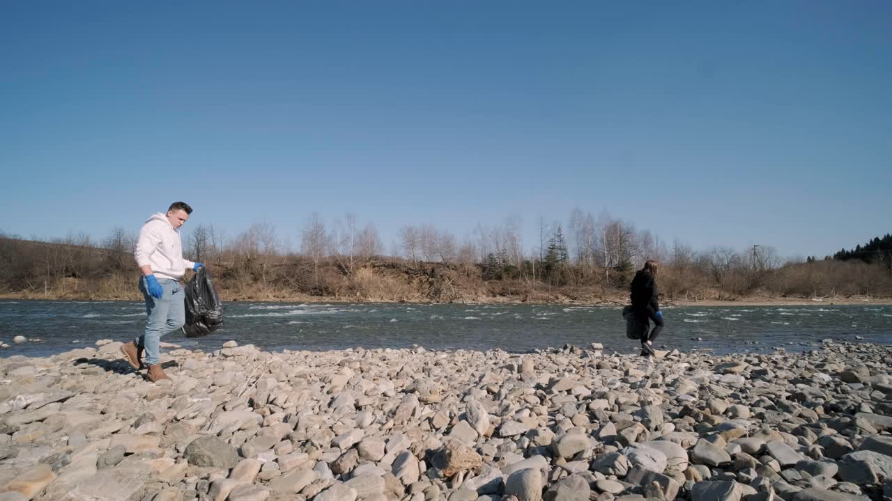 해변에서 플라스틱을 청소하는 팀워크: 자원봉사자들이 쓰레기 봉투에 쓰레기를 모으고, 플라스티크 오염과 환경 문제 개념: 플래스틱에서 자연을 자발적으로 청소하는 것, 지구를 녹색화하는 것