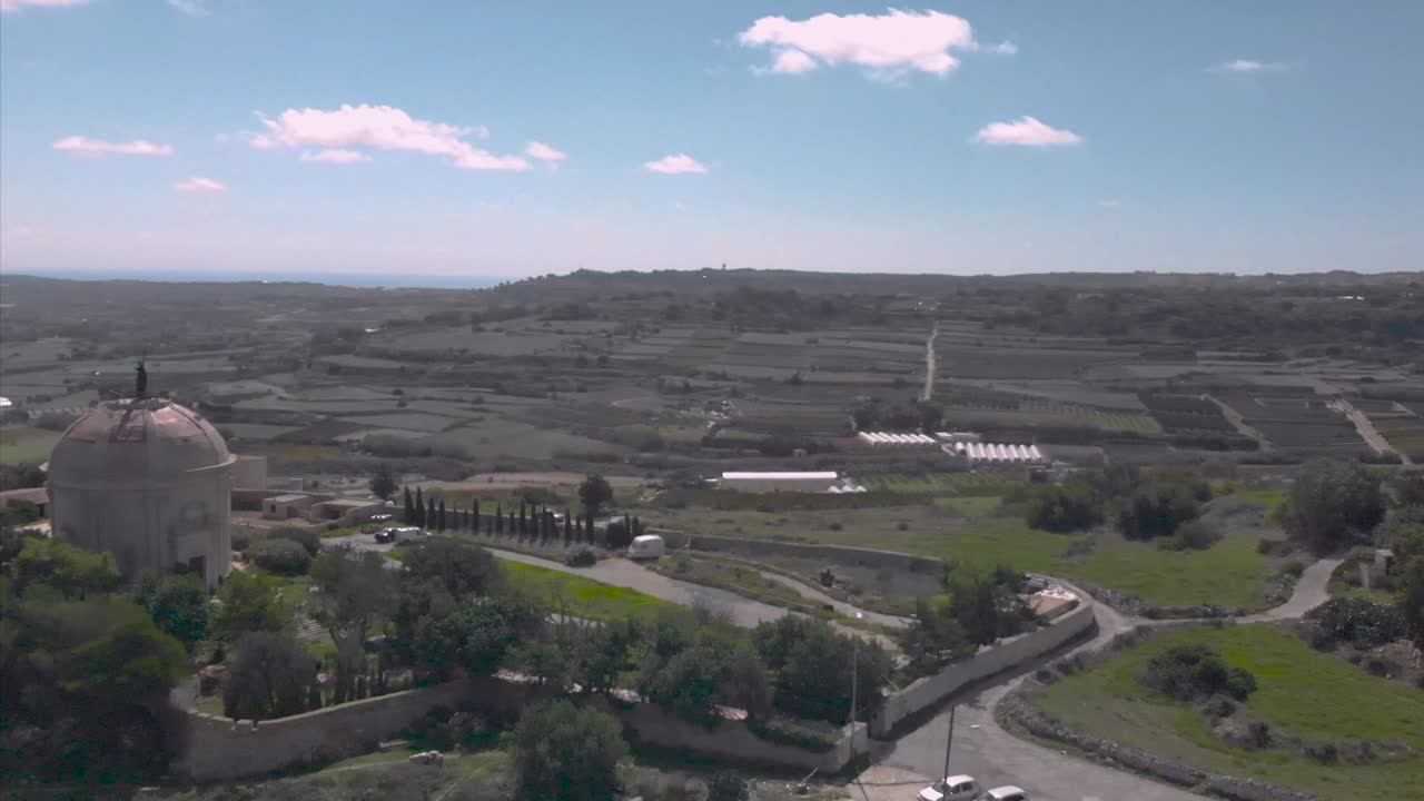 들판과 예배당 옆을 비행하는 드론 샷