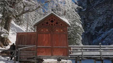 Cabaña-De-Montaña-De-Madera-En-La-Superficie-Congelada-Del-Lago-Braies,-En-Los-Dolomitas-Nevados,-Alpes-Italianos