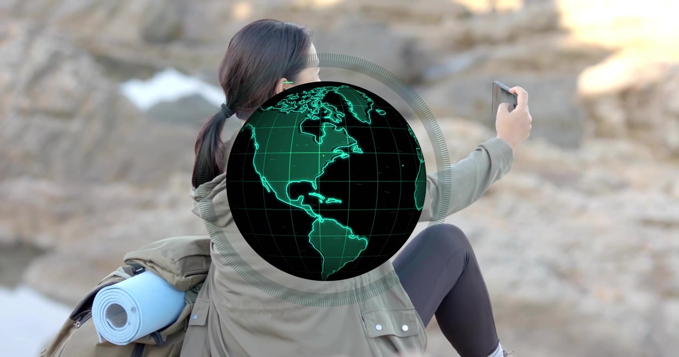 Mulher de meia-idade levantando smartphone na costa, animando um globo de viagem giratório mostrando regiões do mundo