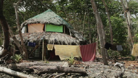 clothes and bed sheets drying outside rustic hut at the darien gap in colombia
