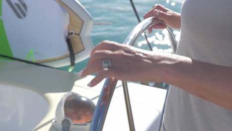 Person's-Hand-On-Steering-Wheel-Of-Boat---Sailor-Driving-A-Boat-At-Dent-Island,-Queensland,-Australia