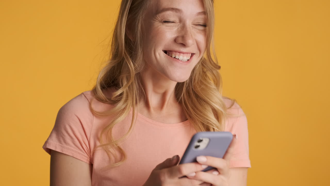 Kaukasisk kvinde bruger smartphone og bliver begejstret.