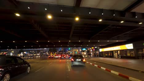 a nighttime driving scene from a car's perspective in berlin, passing by the zoologischer garten area. city lights and modern architecture create a vibrant urban atmosphere.