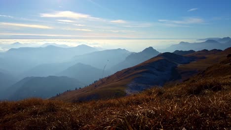 Lapso-De-Movimiento-En-La-Cima-De-Una-Montaña,-Mirando-Al-Horizonte-Interminable-Donde-Las-Montañas-Se-Derriten-Con-El-Cielo