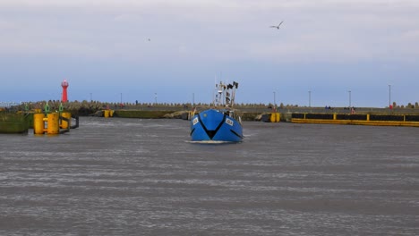 Blue-Fishing-Boat-Enters-Harbor-in-Kolobrzeg,-Poland