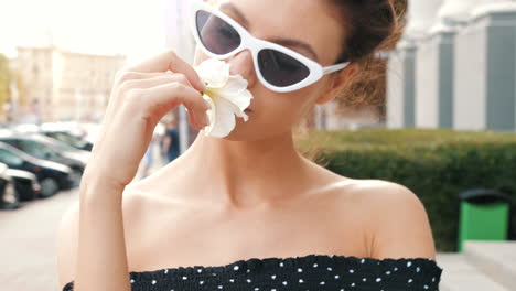 woman smelling a flower in the city