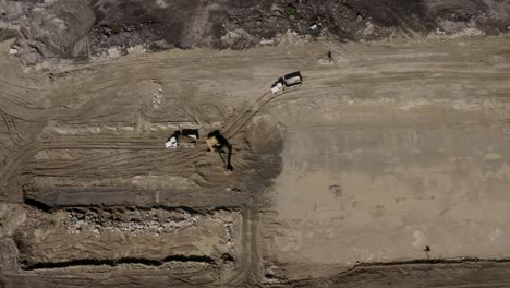 Luftaufnahme-Von-Oben-Nach-Unten-Von-Schwerem-Gerät,-Das-Auf-Einer-Schmutzigen-Baustelle-Arbeitet