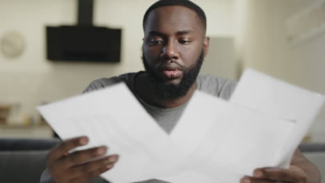 hombre afroamericano comprobando documentos en el lugar de trabajo