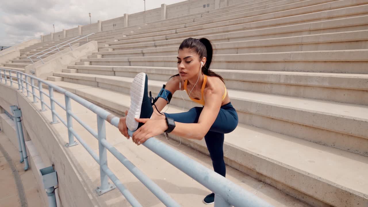 joven atlética estirándose y escuchando música al aire libre