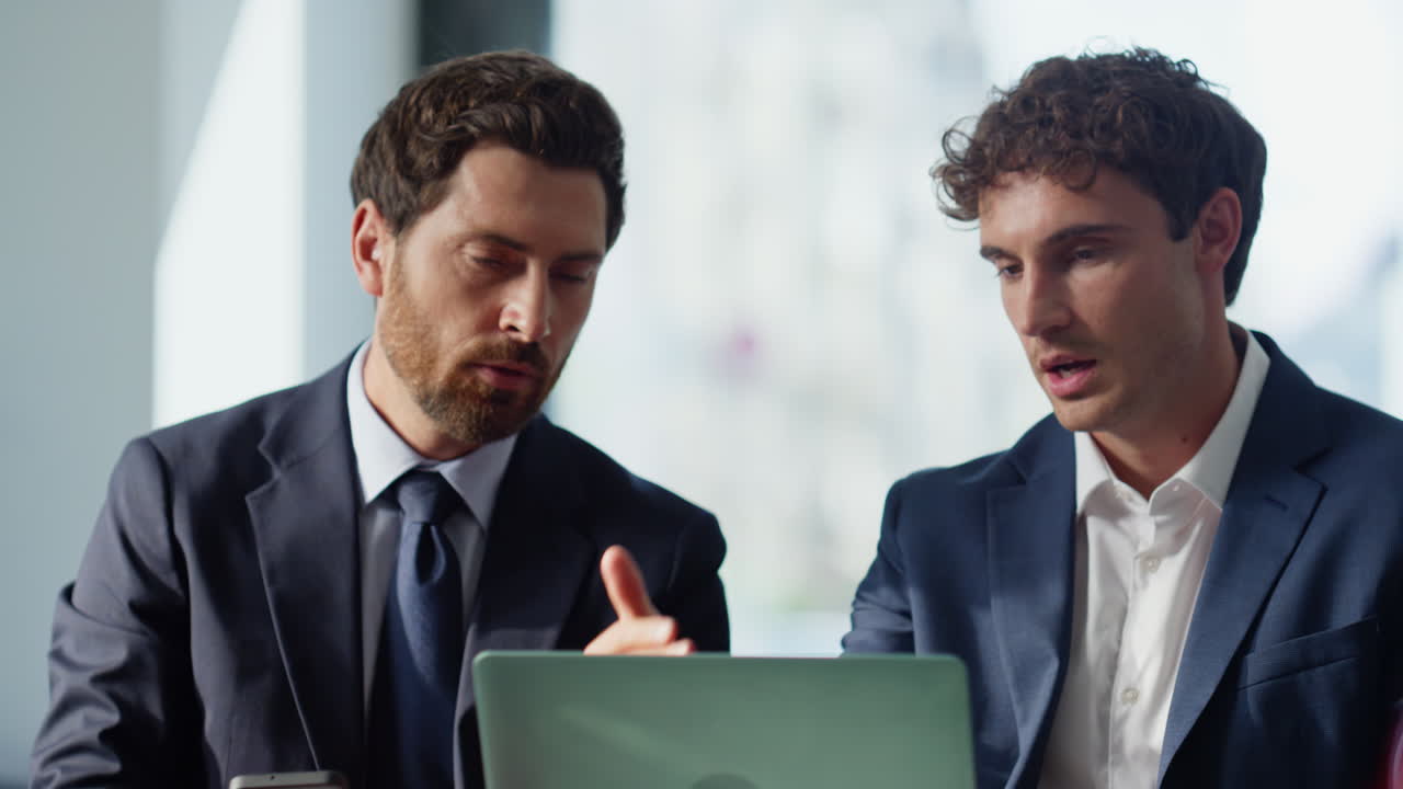 Talking partners looking laptop at panoramic cafe closeup. Business colleagues