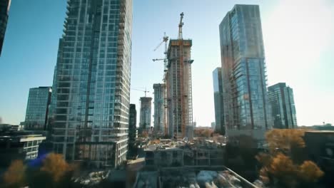 captivating urban evolution: a dynamic view of skyscraper construction surrounded by modern architecture under a brilliant blue sky