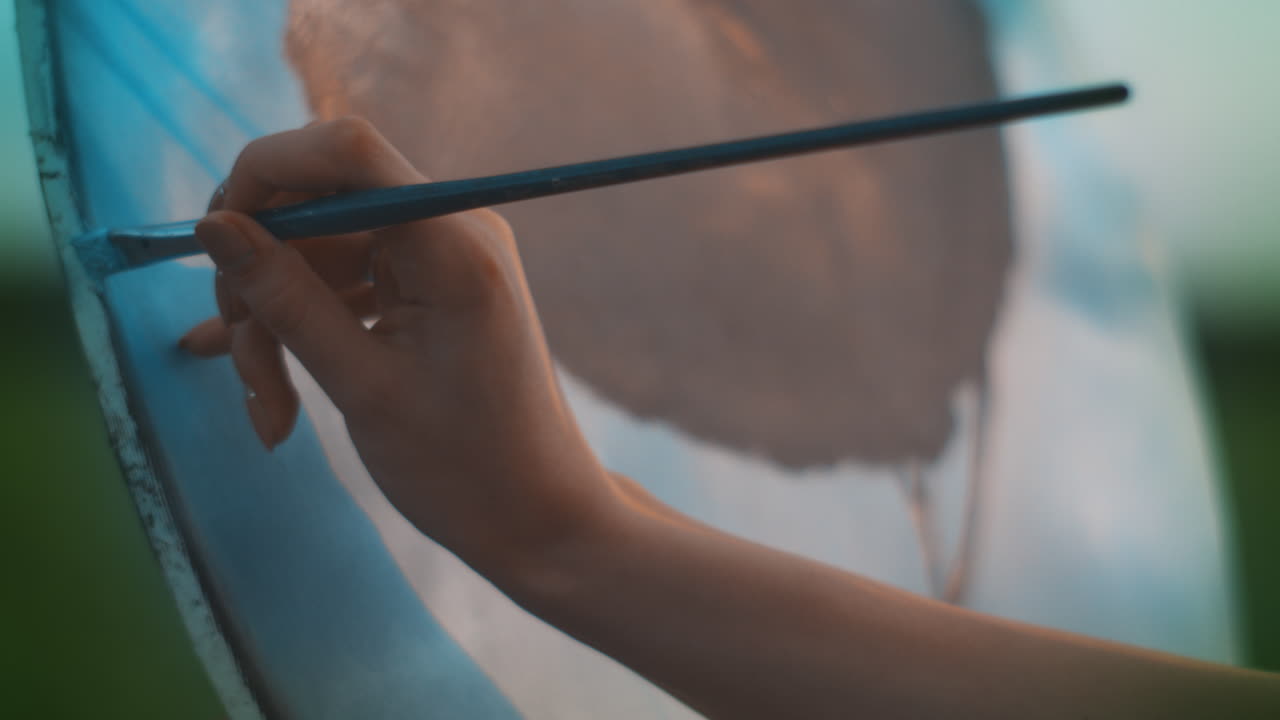 캔버스에 페인트 브러시로 그림을 그리는 여자 손. 직업적인 화가