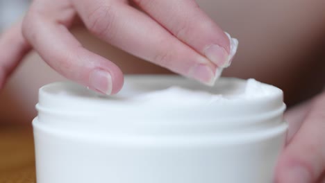 anonymous woman taking body cream from orginal box