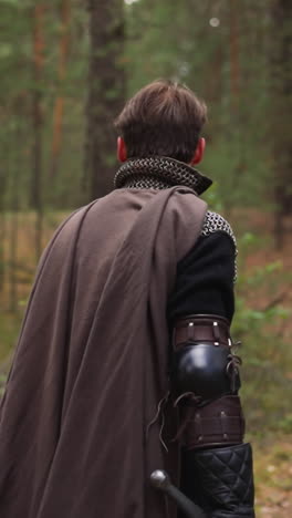 knight in armor walks through forest and looks around, historical medieval costume, ammunition