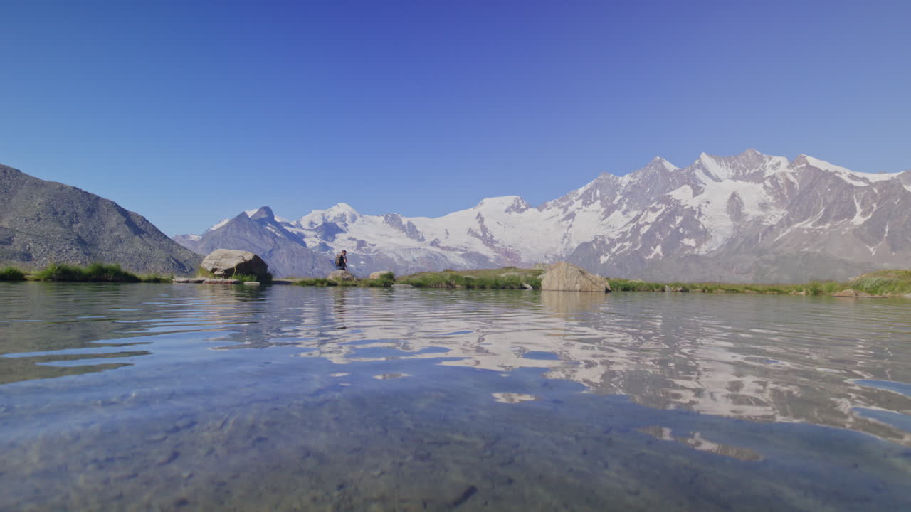Two hikers explore Saas-Fee, Saas-Balen, and the Saas-Almagell dam, passing waterfalls, marmots, and alpine peaks in a breathtaking high-mountain landscape.