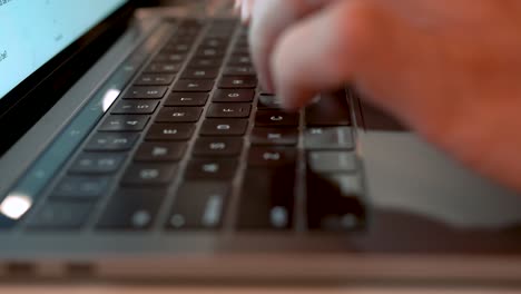 man typing on a laptop keyboard