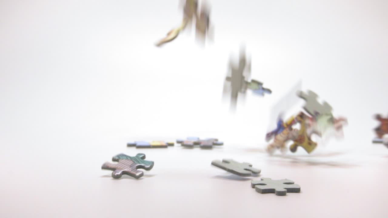 piezas de un rompecabezas que caen sobre la superficie en fondo blanco