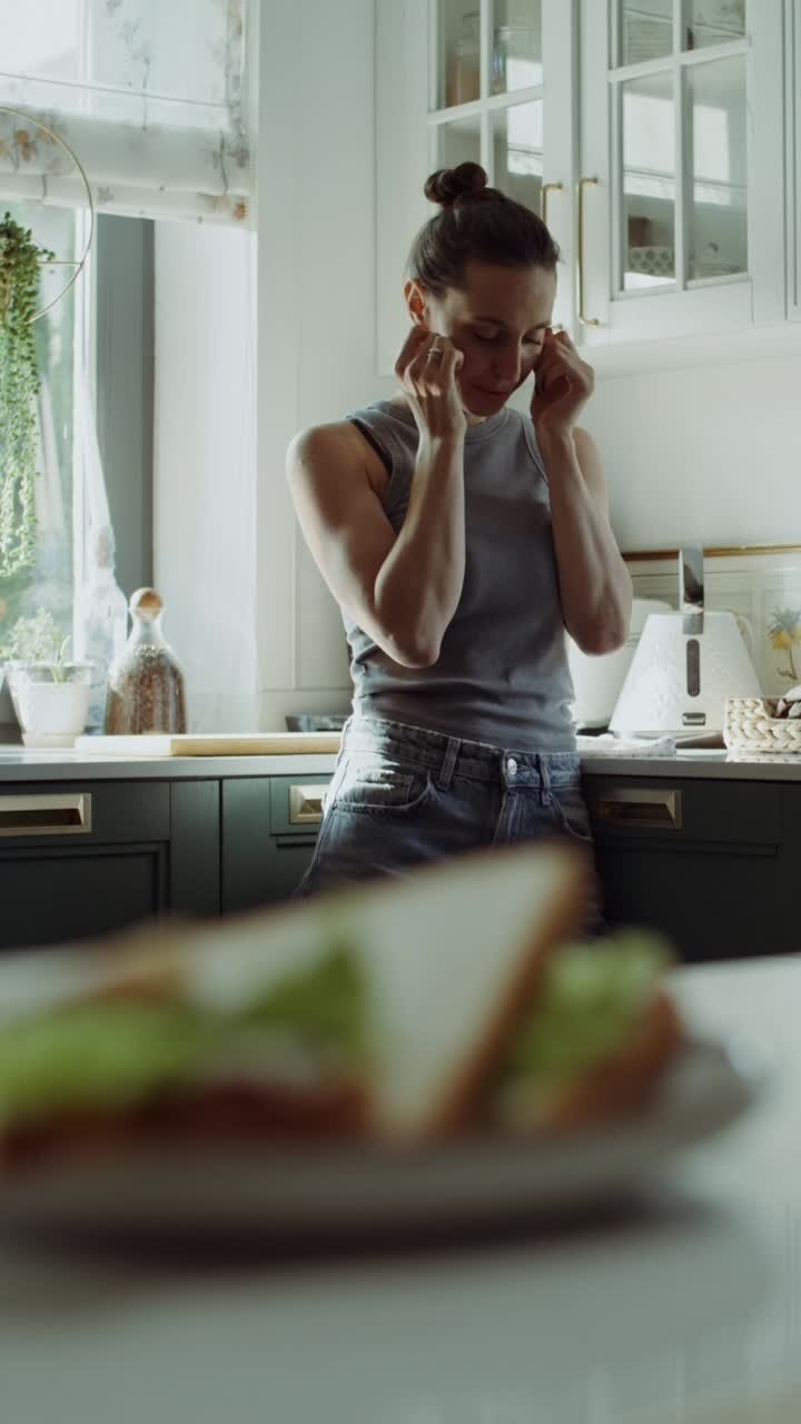 Woman in a kitchen with a sandwich