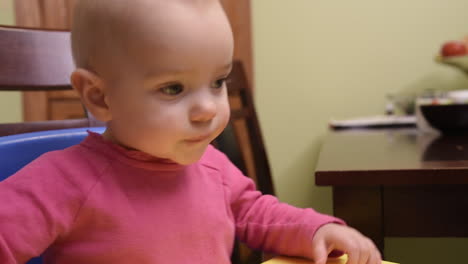 una adorable niña salta de emoción en su trona