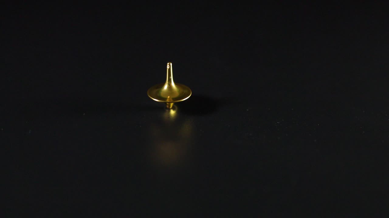 어두운 표면에서 회전하는 황금색 꼭대기