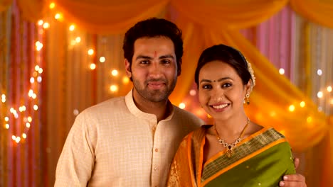 happy indian couple facing towards camera - wearing ethnic traditional dress for a festival