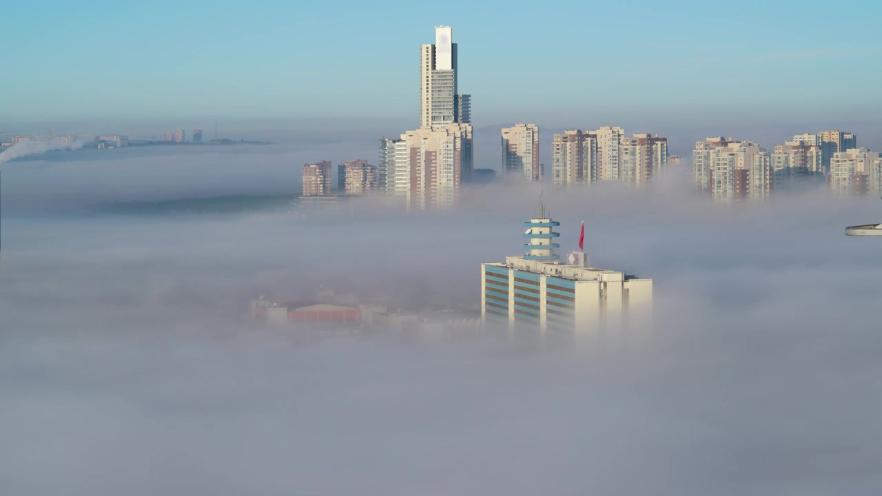 Grattacieli moderni della città che si ergono sopra una fitta nebbia mattutina