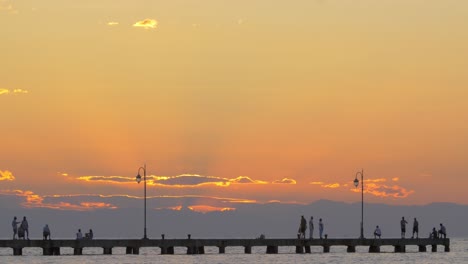 people watching sunset on pier