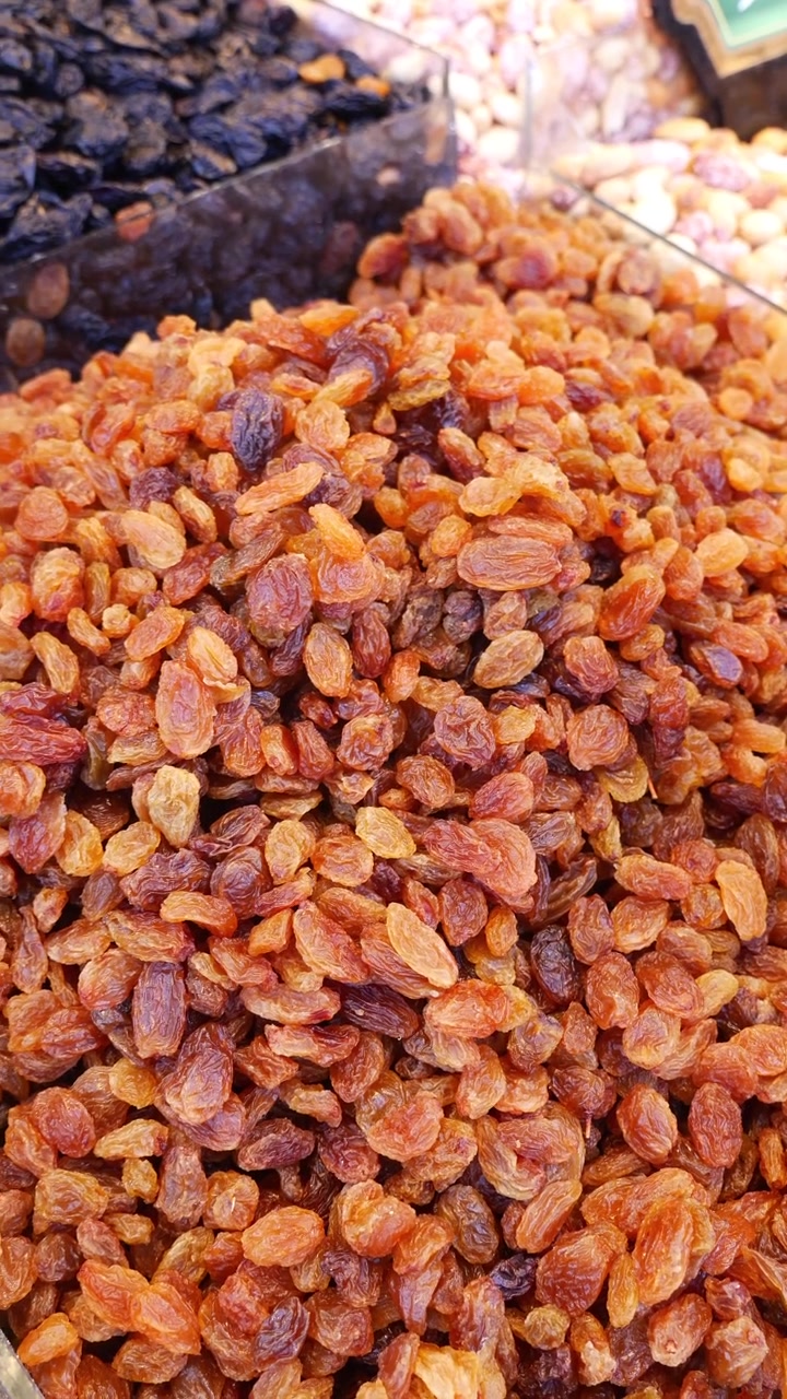 Tas de raisins secs dorés sur un étal de marché.