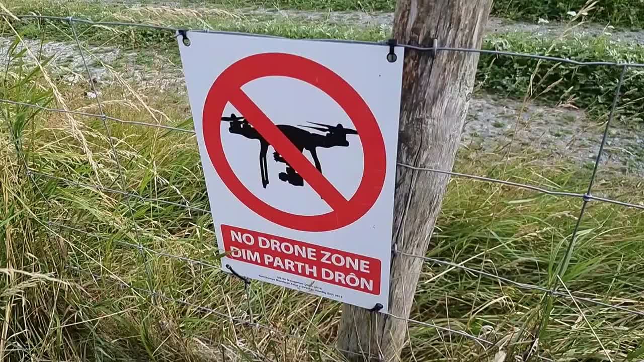 No drone zone restriction notice sign near Welsh Valley airport in Holyhead Wales on wooden fence