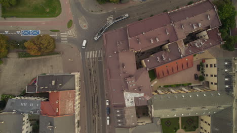 Aerial-view-looking-down-at-tram-travelling-through-Cracow-Poland-urban-European-city-street