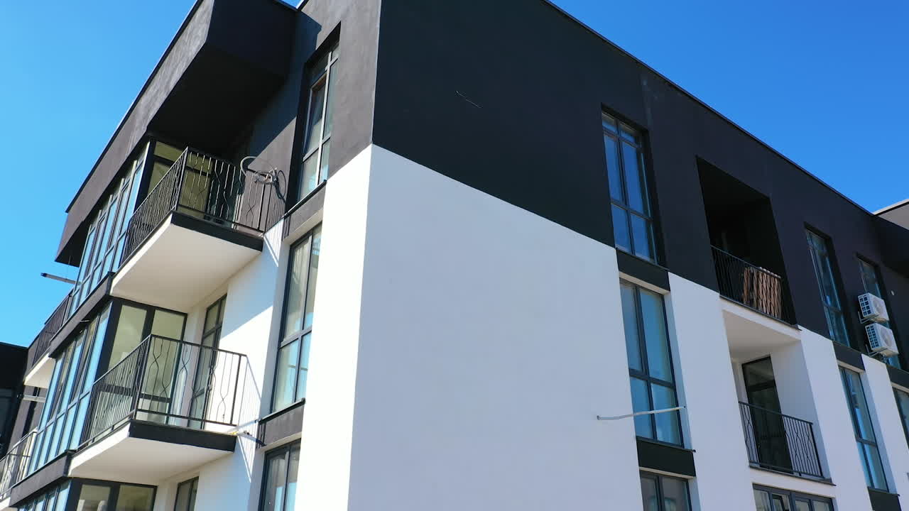 Boligblok mod himlen. Moderne højhus med vinduer og store altaner