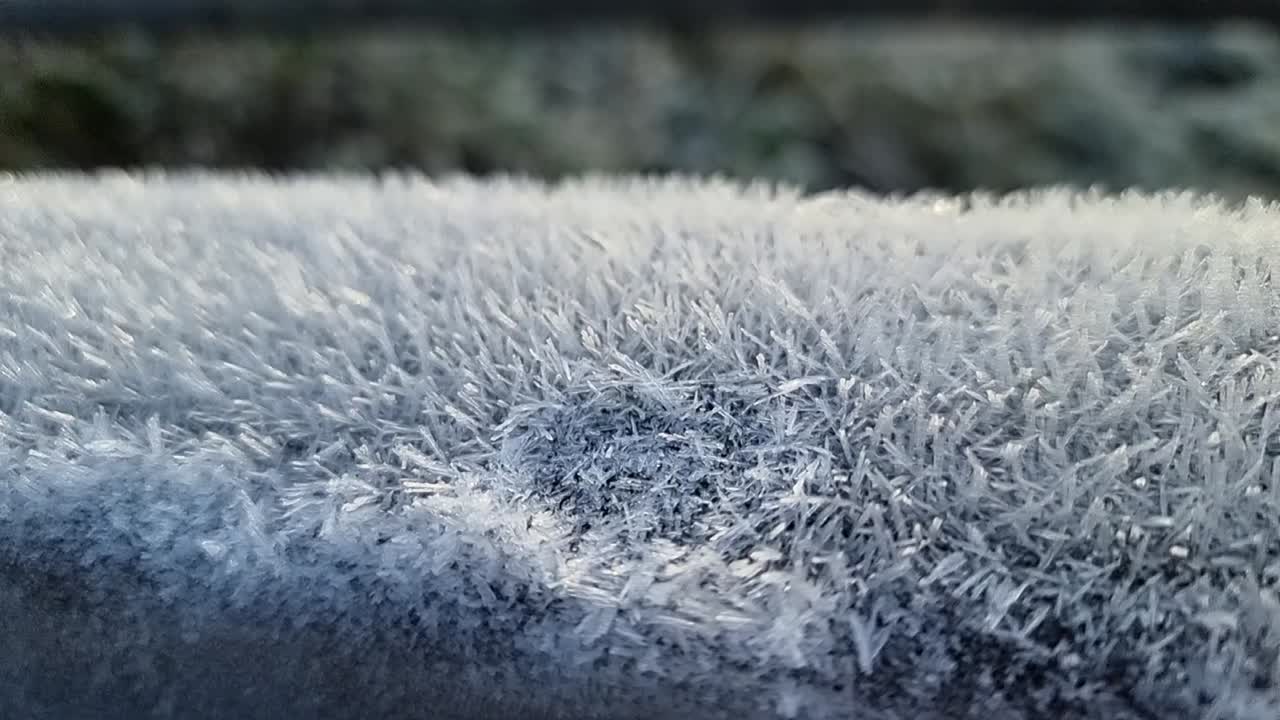 Spiky frost natural pattern close up coating wooden fence in cold winter parkland