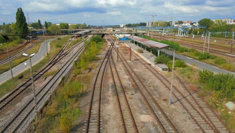 derelict train station platform, modern electric railway tracks, aerial