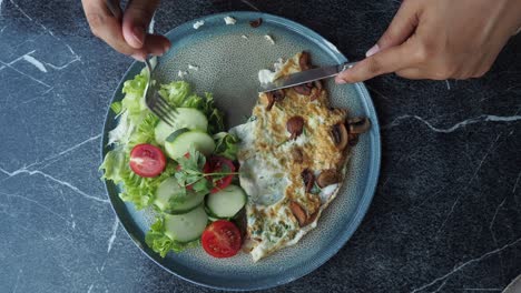 mujer comiendo un hongo y una tortilla de verduras con ensalada