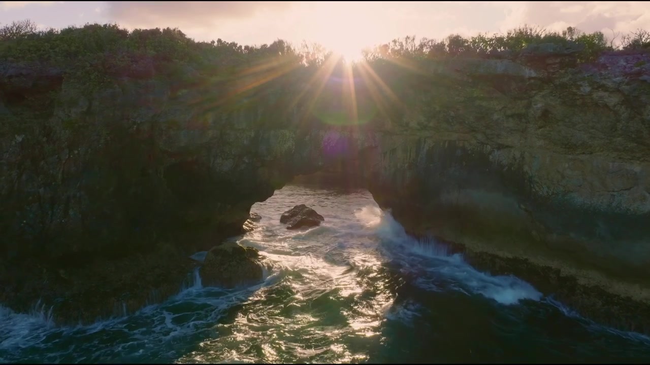 Panorama flight of sunset light behind natural arch with crashing waves in samana, Dominican Republic
